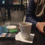 Holding a cup of black coffee in a paper cup｜攝影：Wahyu Kurniawan 圖片來源： Unsplash