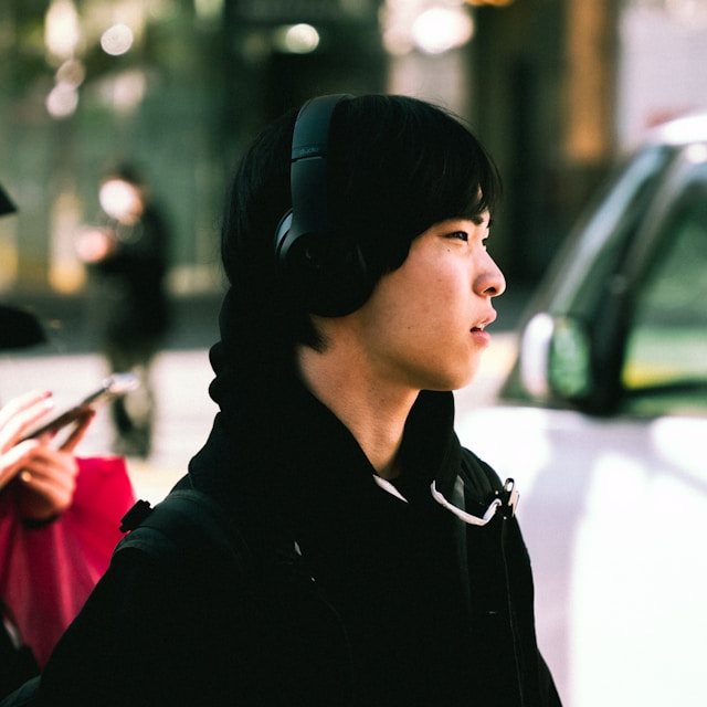 走在路上的年輕人頭戴耳機聽音樂｜攝影｜Ong Cheng Zheng 圖片來源： Unsplash